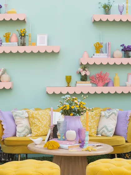 A vibrant yellow sofa set against a mint green wall with pink scalloped shelves, creating a picture-perfect and colorful photo corner.