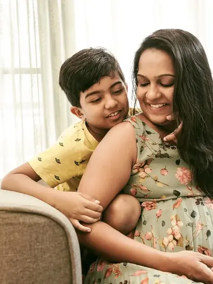 A quiet moment between a pregnant mother and her son. He leans in to connect with her and his future sibling, a sweet photo of a growing family.