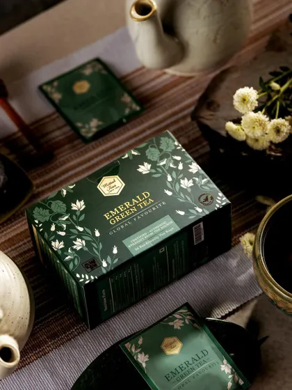 A clean and simple shot of Mittal Teas' Emerald Green Tea box. The product is the hero, with minimal props to suggest a calm and healthy tea-drinking experience.