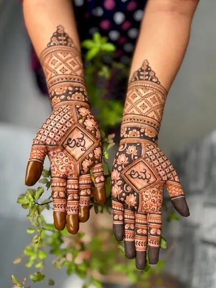 This baby shower mehendi incorporates the words "Amma" and "Appa" (Mother and Father) in Kannada script within diamond-shaped frames, surrounded by lotus patterns.