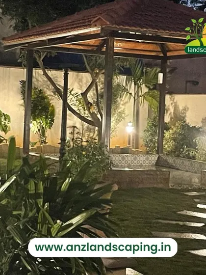 A night view of a backyard garden, where landscape lighting highlights the gazebo, pathways, and surrounding plants, creating a magical atmosphere.