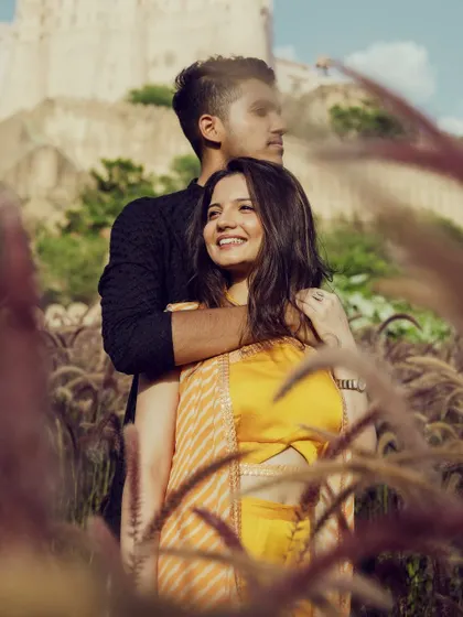 A beautiful shot of the couple surrounded by nature. Her sun-kissed makeup looks fresh and glowing, perfect for an outdoor pre-wedding shoot.