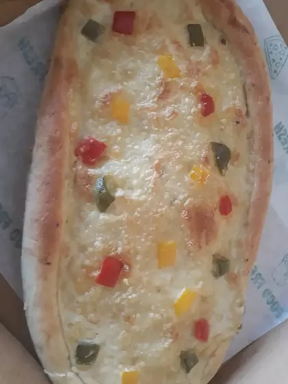 Another view of the boat-shaped vegan Khachapuri, showcasing the golden-baked bread and cheesy filling.