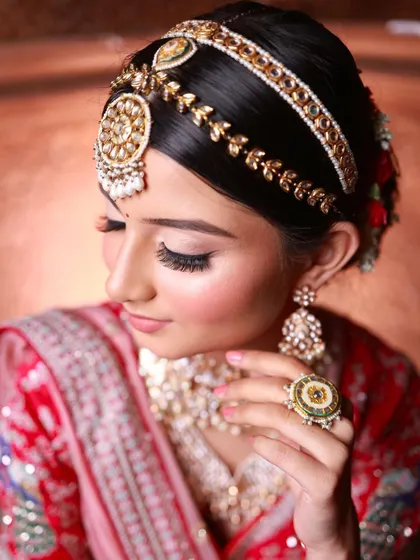 An artistic close-up focusing on the intricate matha patti and eye makeup. Your portfolio will feature these kinds of detailed, beautiful shots.