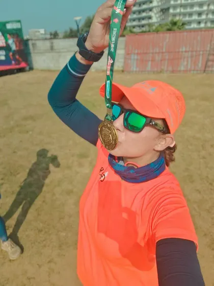 A finisher kissing her medal. This is the sweet taste of victory after a hard-fought race.