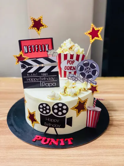 A fun movie-themed cake with popcorn, a film reel, and a Netflix logo.
