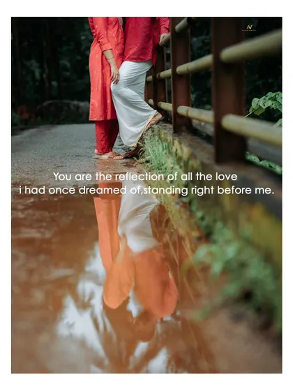 A creative and artistic shot using reflections in a puddle to capture a couple in traditional attire, symbolizing their love story.