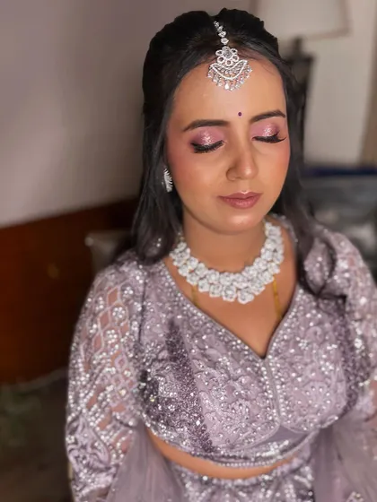 A dreamy reception look in a lavender lehenga. The makeup features soft pink and purple eyeshadow with a subtle lip, paired with diamond jewelry for a touch of sparkle.