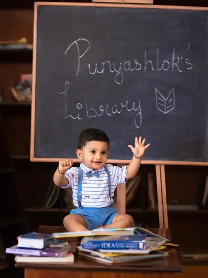 Waving hello from his library! This little scholar is all smiles during his book-themed first birthday photoshoot.