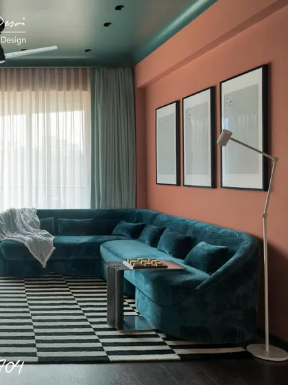 Another angle of the Project 704 living room. The contrast between the deep teal couch and the warm, earthy pink on the walls creates a dynamic yet inviting atmosphere.