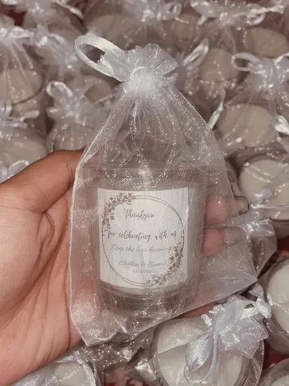 Simple and elegant wedding favors. These mini jar candles are wrapped in white net with a custom tag for the couple.