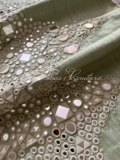 A close-up of the geometric patterns created by the hand-stitched mirrors.