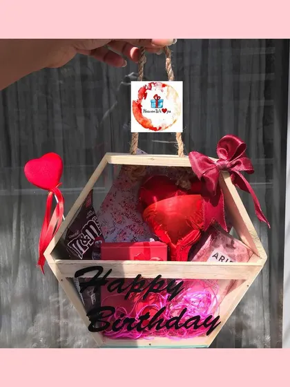 A closer look at our hexagonal wooden "Happy Birthday" box, filled with red treats and perfect for a romantic celebration.