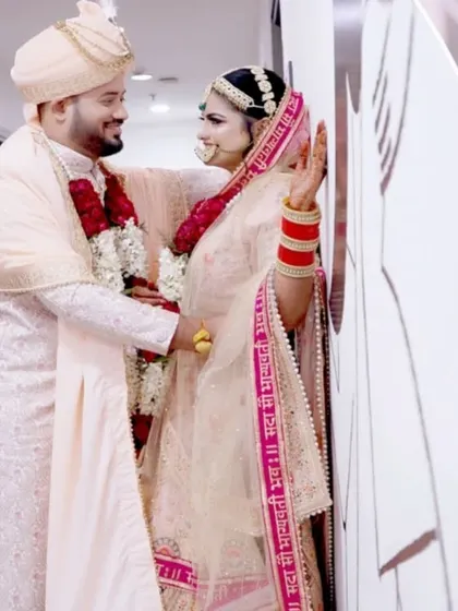 A candid, happy moment between the couple, captured in a hallway during their wedding day.