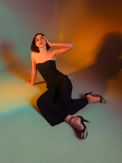 A full-body shot from above, showing the "rainbow" of colored light on the floor. This is a great way to showcase a creative lighting setup.