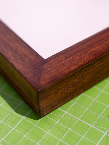 The fine craftsmanship of a mitered corner on one of the solid wood frames we use for our custom framing services.