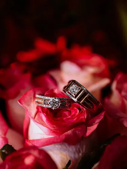 A close-up shot of the engagement rings resting on a bed of rose petals, symbolizing love and commitment.