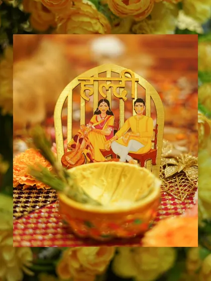 A creative detail shot of the Haldi ceremony decor, featuring a bowl of turmeric paste and a cute caricature.