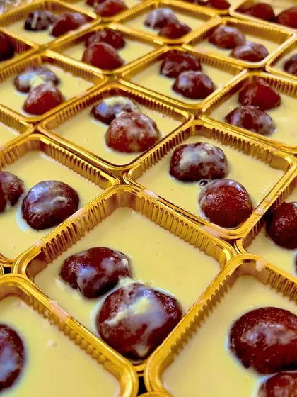 Our Kala Jamun served with Basundi. These dark, rich jamuns are soaked in a creamy, thickened milk sauce, offering a luxurious twist on a classic Indian sweet.