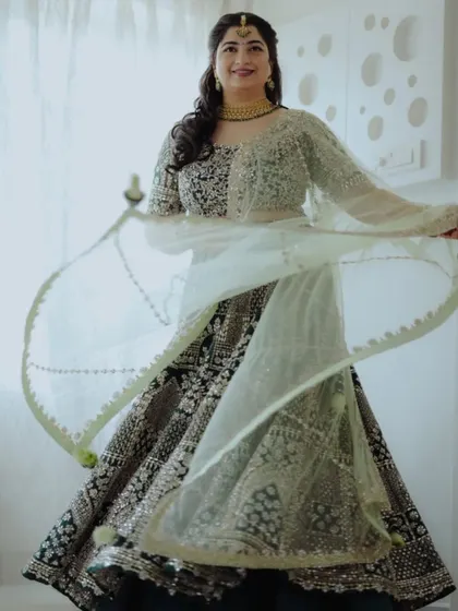 A bride shows off her beautiful lehenga with a playful twirl.