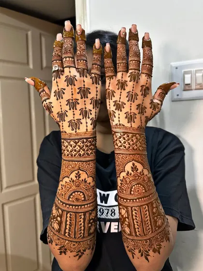 This design focuses on the beauty of the lotus, with patterns flowing from the palm all the way up the fingers. It's a modern take on traditional bridal mehndi, perfect for the contemporary bride.