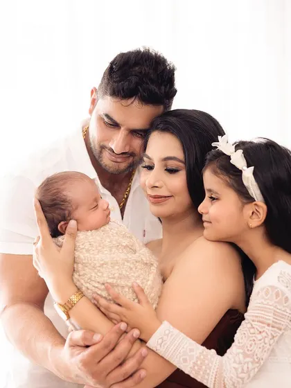 The whole family comes together to welcome their newest member. This portrait captures the love and excitement of a family of four, blending newborn and family photography.