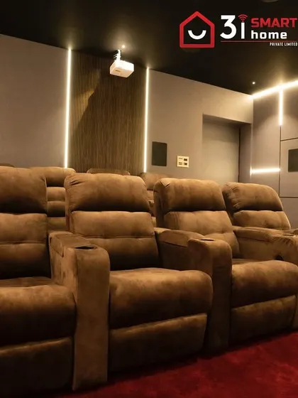 A closer look at the comfortable, fabric-upholstered recliners. The warm lighting and red carpet make this a cozy yet exciting space to watch movies.