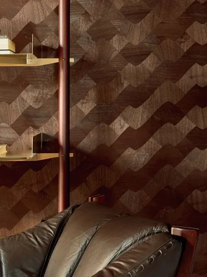 A wall featuring the 'Le jeu de dame' wood marquetry wallcovering. The design transforms thin slices of wood into a fluid, wavy pattern, blending dynamic motion with the natural elegance of the material.