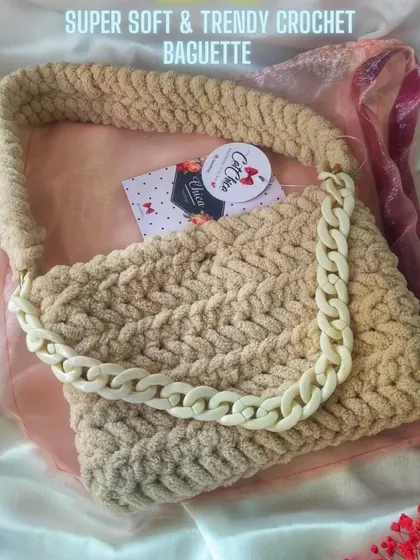 A super soft and trendy crochet baguette in a neutral beige color, with a matching chunky chain.