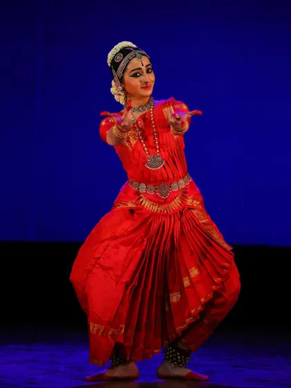 A dynamic pose captured against a blue background, showing the versatility of the performance across different lighting and stage setups.