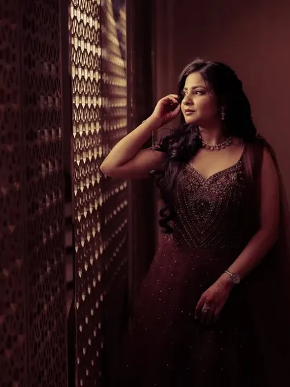 A thoughtful portrait of a woman by a window, capturing a moment of quiet contemplation.