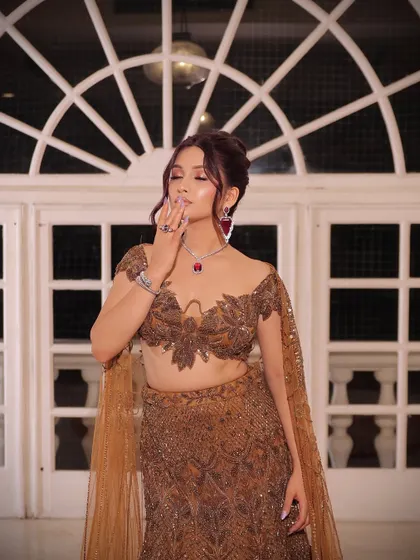 A close-up of the bride, showing her soft, smoky eye makeup and the intricate details of her blouse.
