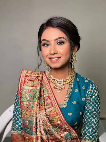 A portrait of a happy bride, her hair styled in a simple, elegant updo that transitions into a braid, perfect for a traditional Mandwa ceremony.