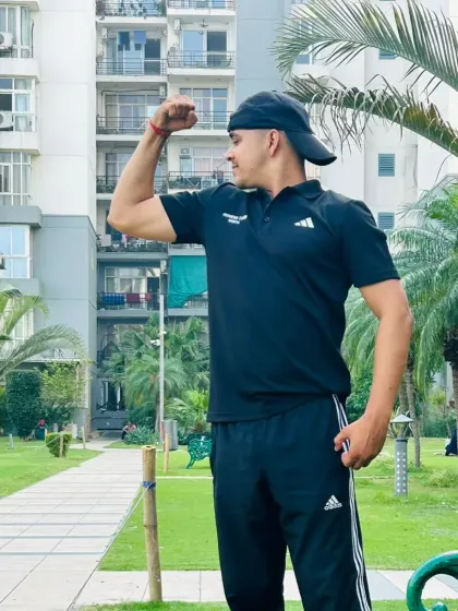 Side bicep pose in the park.