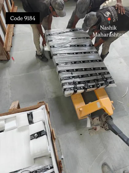 The wrapped granite waterfall panel is moved on a pallet jack, ready to be placed in its crate.