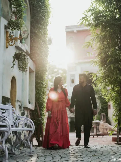 A walking shot of a couple through a European-style alleyway. The warm sunlight and charming architecture create a romantic, storybook feel right in the middle of the city.