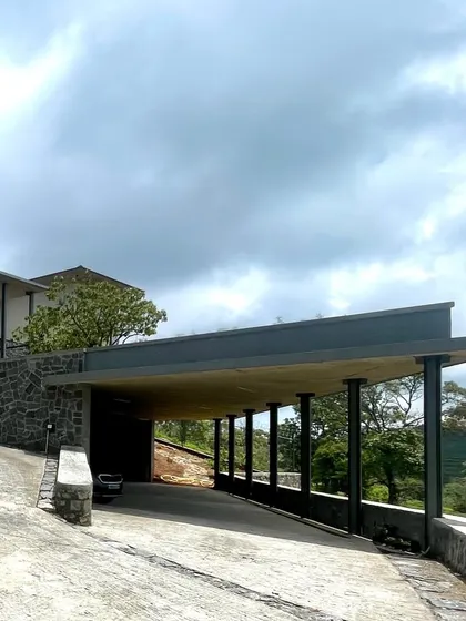 The entrance to a weekend retreat in Kotagiri, designed to feel like it's taking flight from the hillside. The structure spans three levels, following the land's contours to maximize views of the western valley.