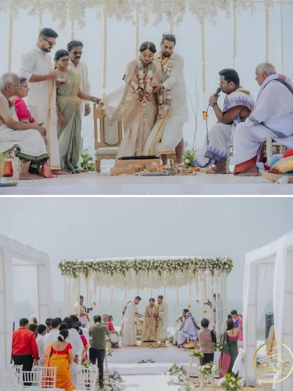 The couple performing wedding rituals under an elegant white mandap, with guests watching on.
