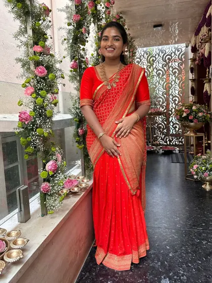 A lovely client in a red bandhani-style saree, paired with a simple, elegant red blouse. This is a perfect look for a pre-wedding pooja or festive gathering.