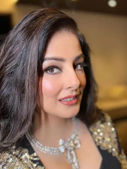 A close-up portrait of a client with voluminous, bouncy curls. This glamorous hairstyle is perfect for a cocktail party or reception, adding a touch of drama and sophistication.
