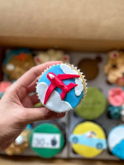 This travel-themed cupcake features a fondant airplane flying through the clouds.