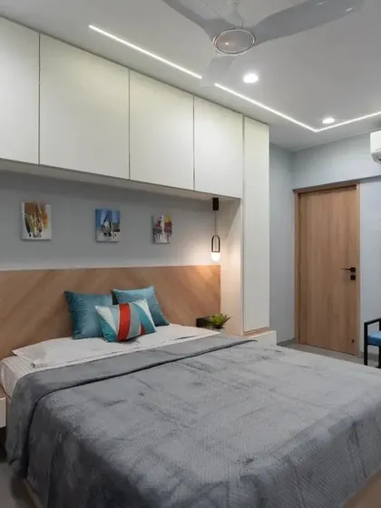 This shot highlights the clever use of space, with storage built in above and around the bed. The combination of white and wood keeps the room feeling bright and warm.