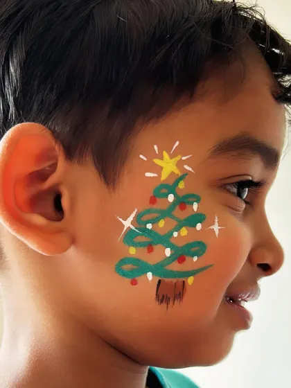 A Christmas tree complete with lights and a star on top. This detailed cheek art is perfect for holiday parties.