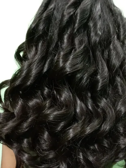 A close-up of these gorgeous, glossy curls. This shows the texture and definition I can create, perfect for adding volume and bounce to your hair.