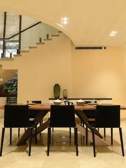 Creating delightful dining experiences. This space combines a modern dining set with an arched ceiling and views of the staircase, making every meal feel special.