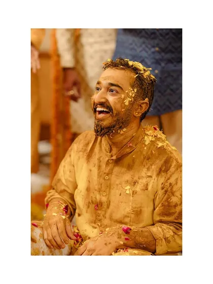 The groom's turn! His happy, laughing face as he gets covered in turmeric paste.