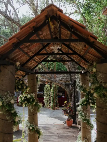 An entryway with pillars wrapped in delicate floral garlands.