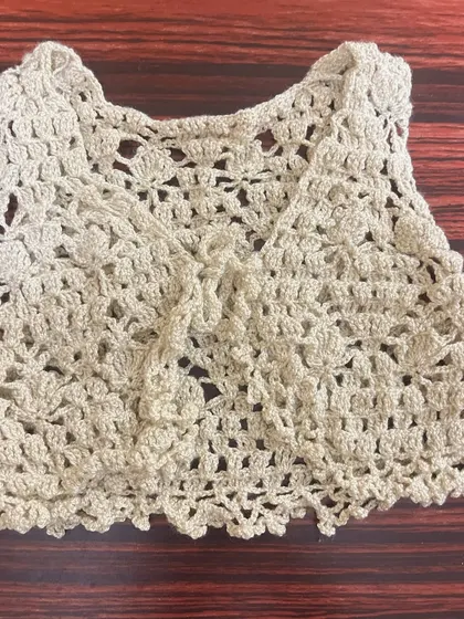 Another view of the beige crochet vest, this time showing the simple tie-front closure.