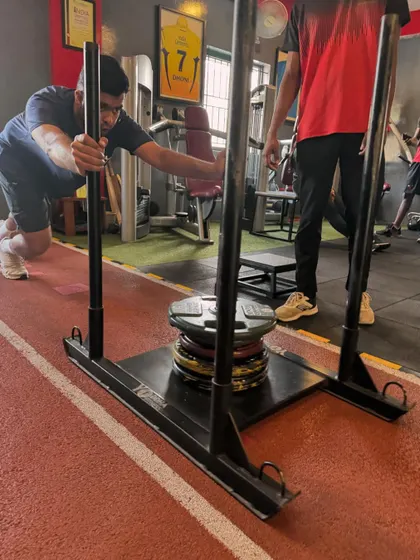 A client digs in for a heavy sled push, a full-body effort that tests strength and willpower.