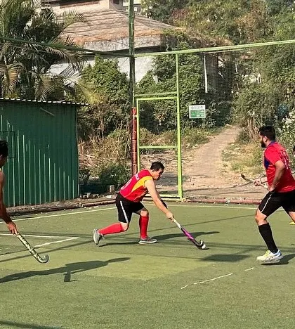 A player in red advances the ball down the field during a practice game. Our training focuses on creating dynamic attacking opportunities and fluid movement.